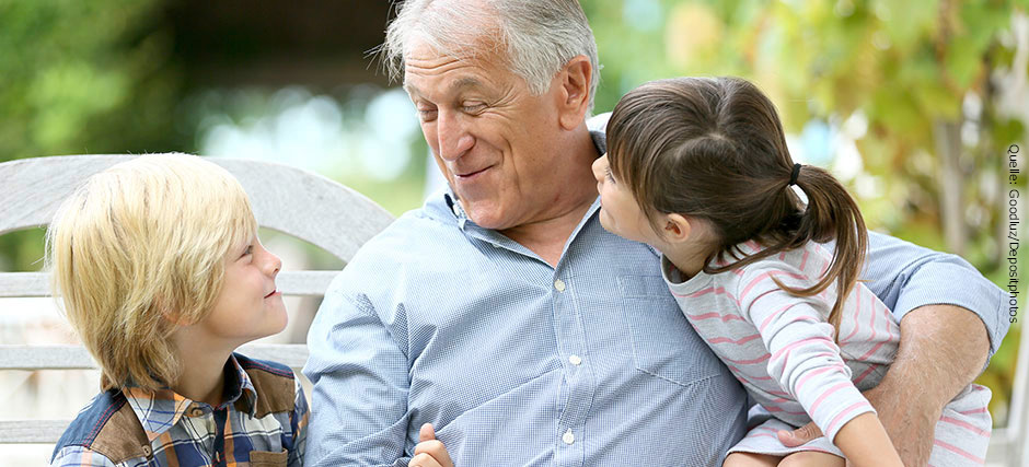 Glücklicher Großvater sitzt mit seinen Enkelkindern auf einer weißen Holzbank. 