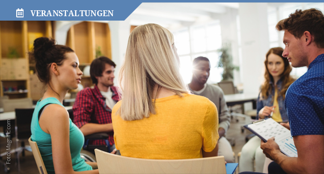 Menschen sitzen in einer Runde auf einer Veranstaltung und diskutieren