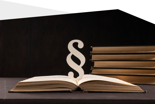 Aufgeschlagenes Buch mit Paragrafenzeichen