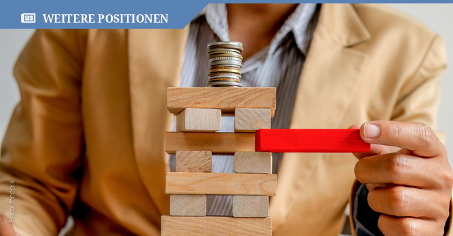 Mann im Anzug zieht roten Jengastein aus Turm