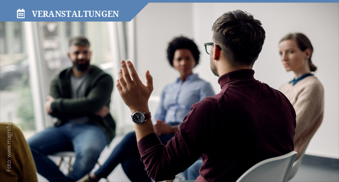 Gruppe diverser Menschen sitzt in einem Kreis und diskutiert